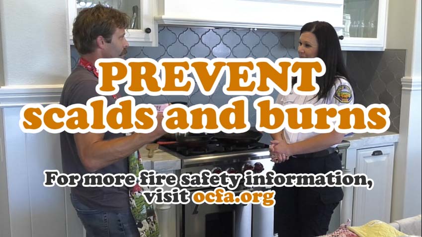 Cooking Safety - PREVENT scalds and burns. A female educator stands in front of a kitchen stove and teaches "Silly Steve" about fire safety.
