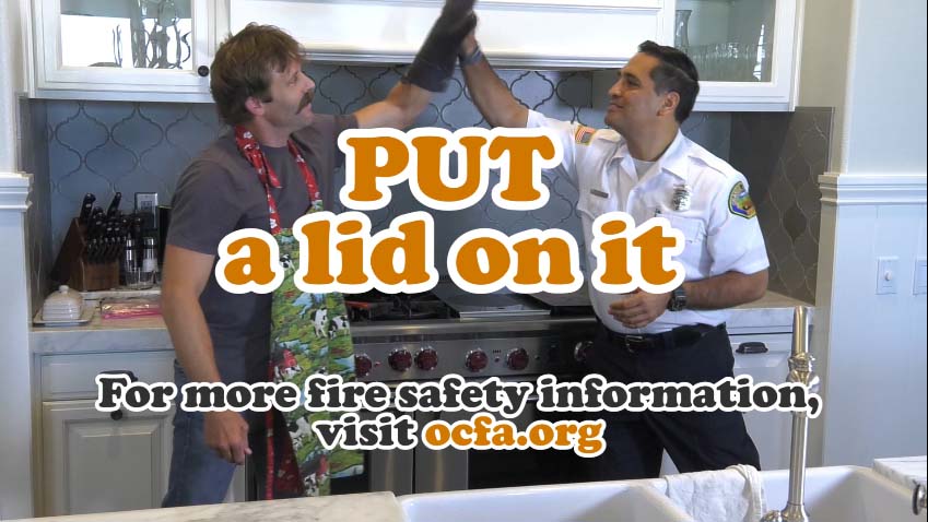 Cooking Safety - PUT a lid on it. An educator high fives "Silly Steve" in front of a kitchen stove